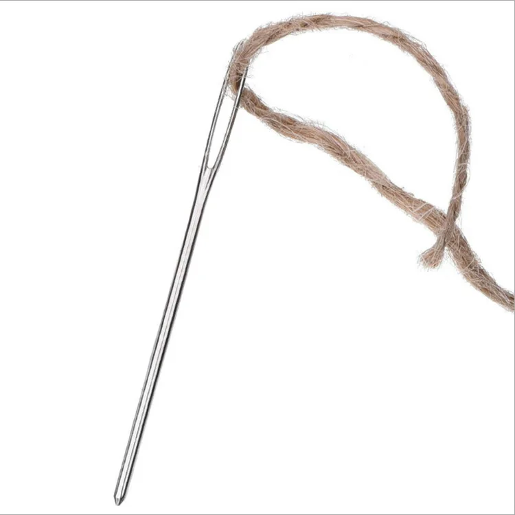 Aiguille à grand chas enfilée d'une ficelle