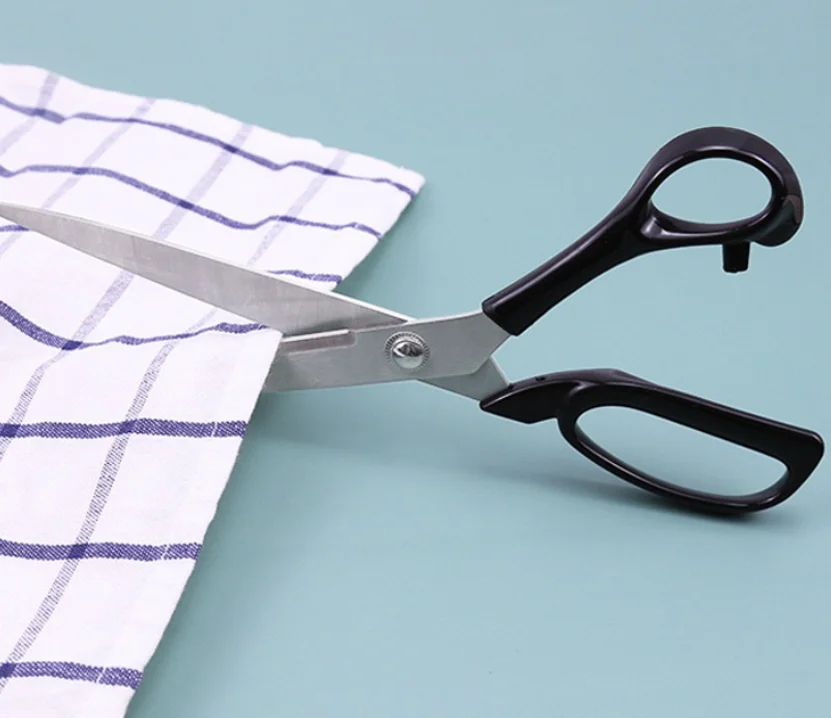 Ciseaux de tailleur coupant un tissu à carreaux