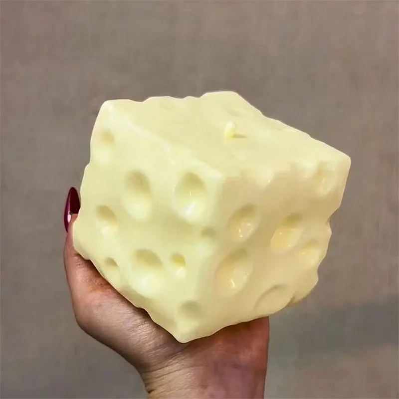 Cube anti-stress en forme de fromage tenu en main