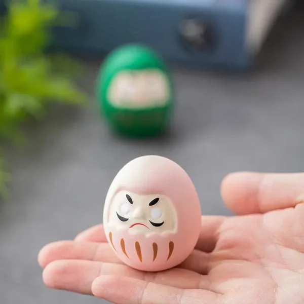 Daruma rose dans la main