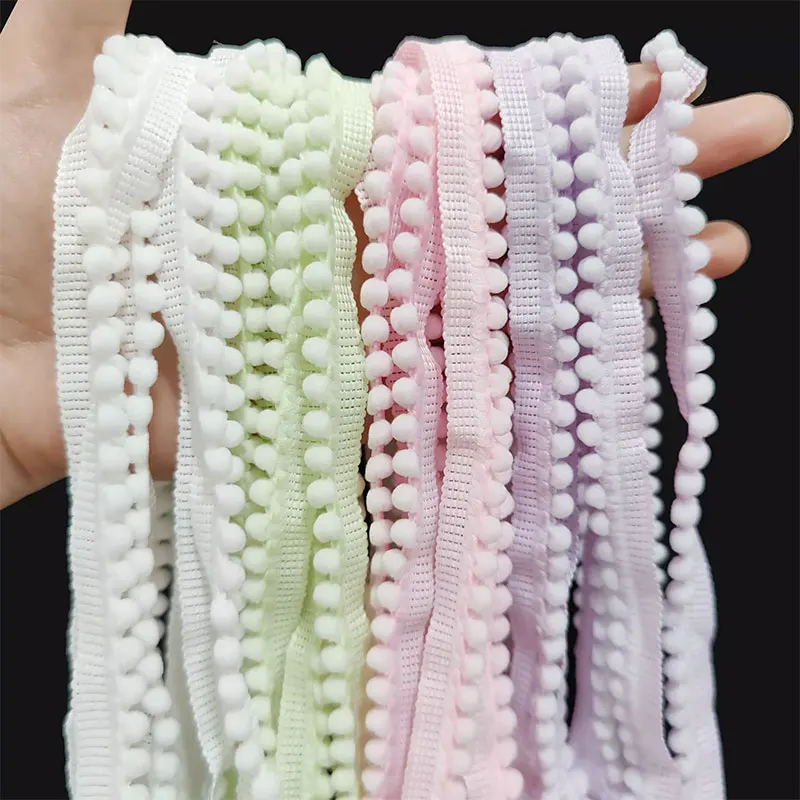 Galons à pompons pastel dans la main