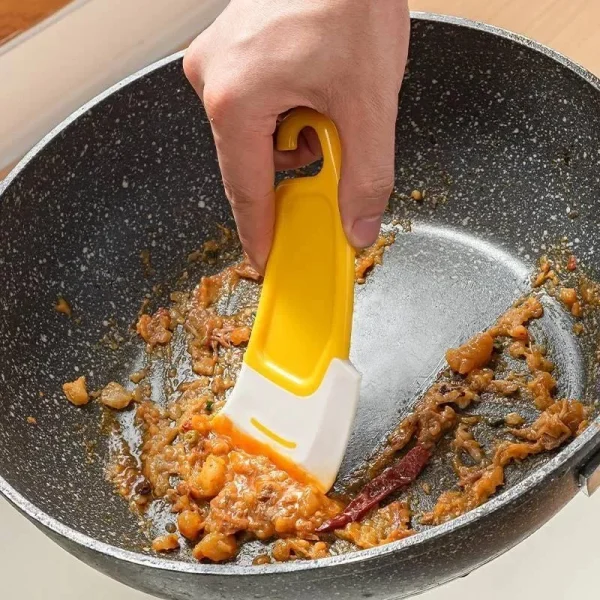 Racler une poêle avec le grattoir en silicone