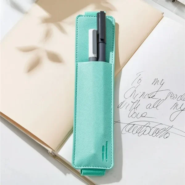 Étui turquoise sur un carnet