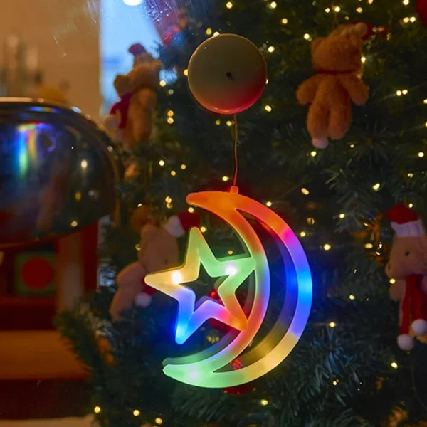Lune et étoile lumineuses devant un sapin