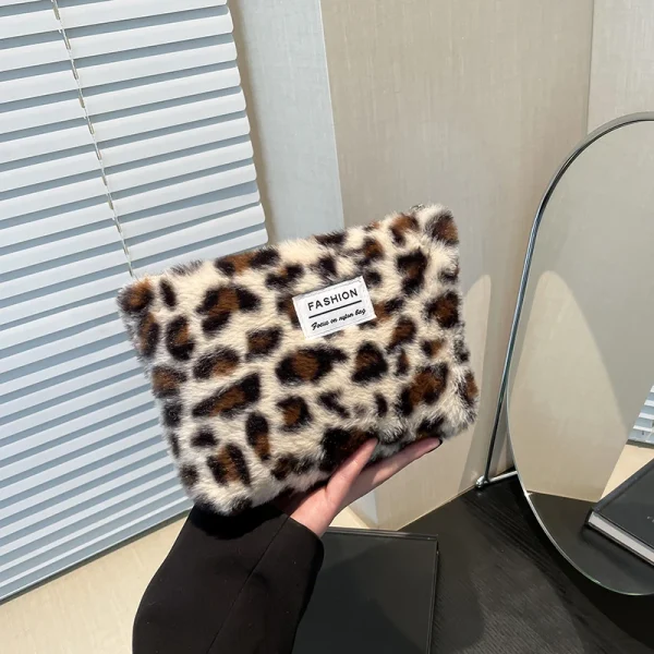 Trousse beige en main